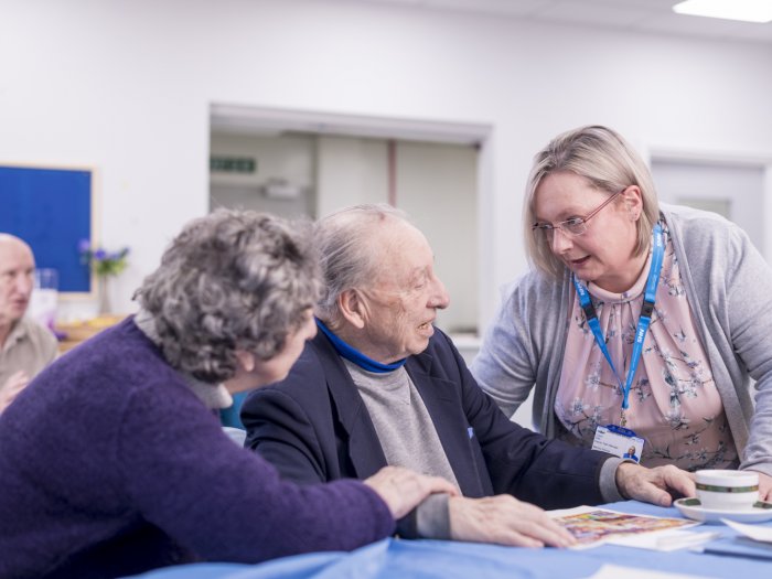 Woman clinician medic talking to an elderly man and woman