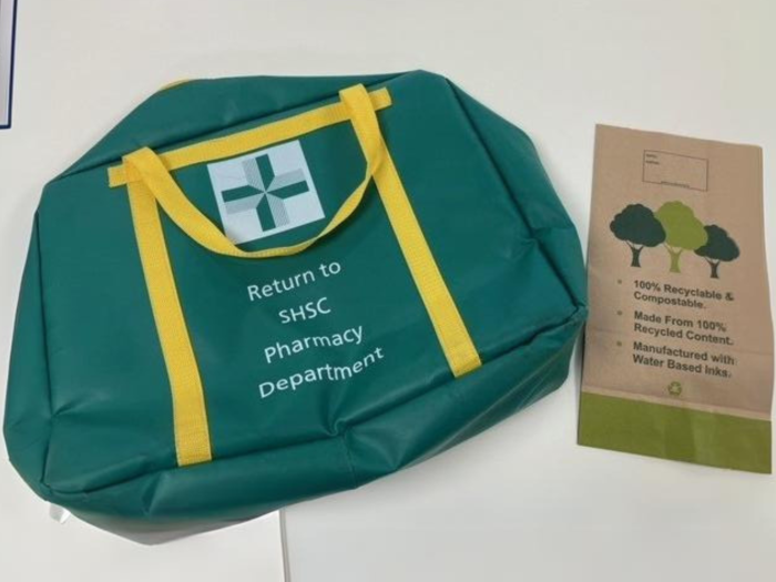 Green pharmacy medication bag alongside a paper medication bag