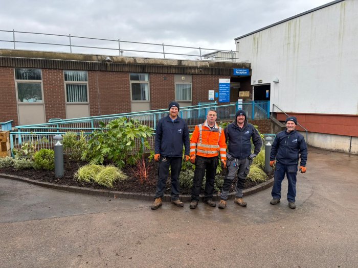 Gardening team stood in front of newly planted bed outside Longley centre entrance